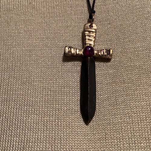 Sword-shaped pendant like new with red stone and leather cord
