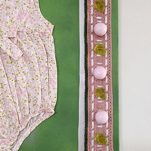 Handmade canvas frame with baby romper, pink flowers, beads, and lace