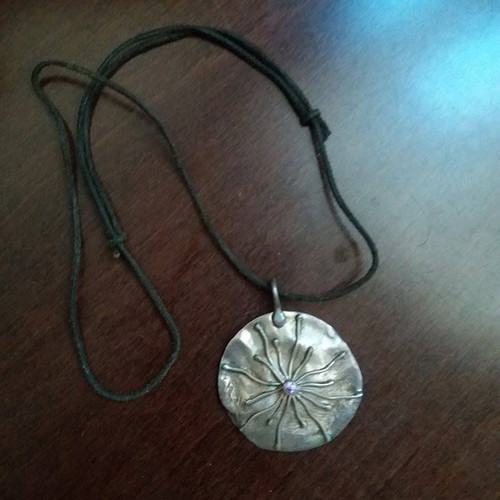 Silver pendant used on leather with purple stone