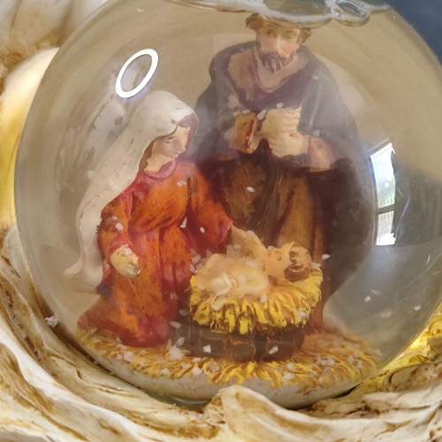 Christmas decorative snow globe featuring the Nativity and a base shaped like an angel's wing