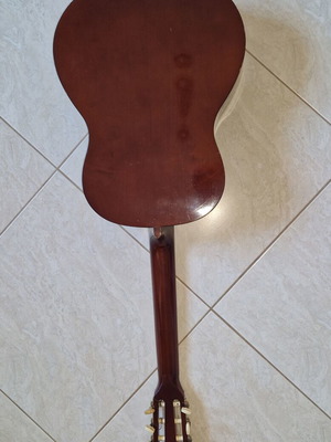 Classical guitar used with case, missing one string and small hole