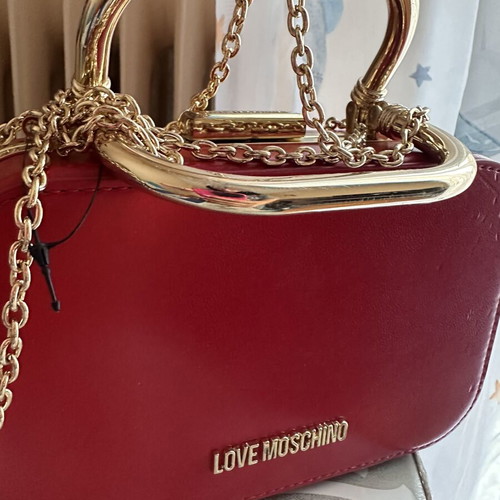 Love Moschino red shoulder bag like new with gold metal clasp and embossed detail