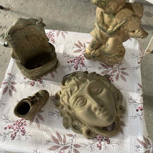 Decorative clay items in gold color, including Gorgoneion