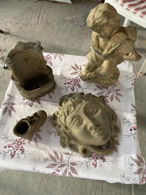 Decorative clay items in gold color, including Gorgoneion