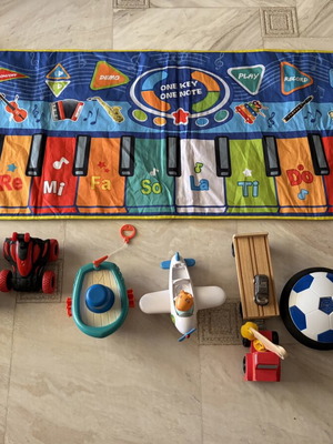 Toy set used with musical mat piano, remote car, boat, airplane, truck, football, figurine