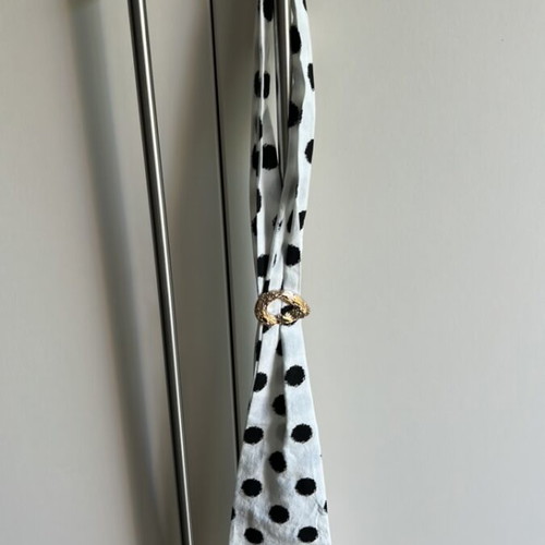 Black and white polka dot neck scarf with gold brooch