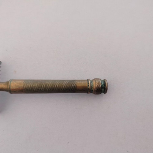 Vintage brass razor used with visible wear and oxidation