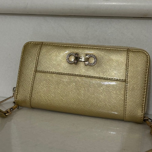 Two gold wallets, one with wrist strap