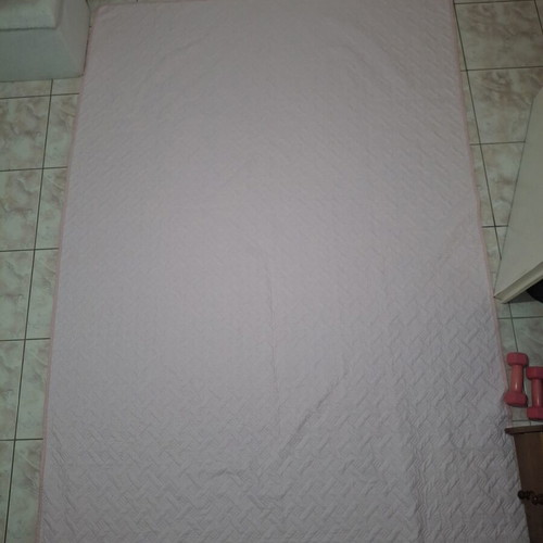 Quilted bed cover in soft pink