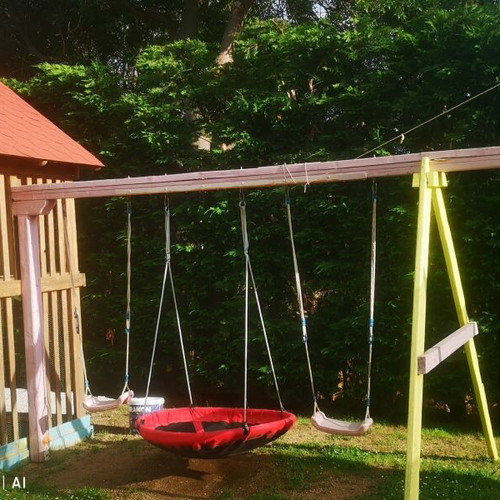 Playground set used with trampoline, seesaw, slide, and swings
