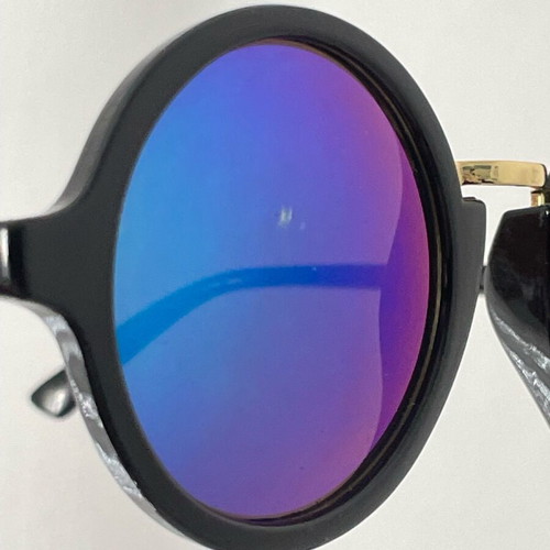 Sunglasses with round iridescent lens used, black frame with gold detail