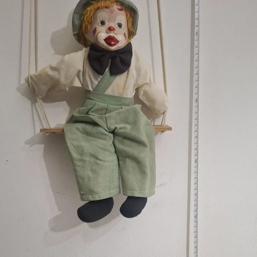 Porcelain clown doll on wooden swing, vintage collectible