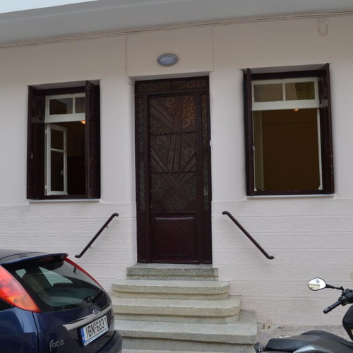 Iron exterior door used with carved wooden window shutters