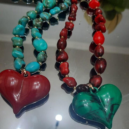 Two handmade beaded necklaces with heart pendants, red and green