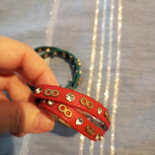 Leather bracelets used, red and green with charms