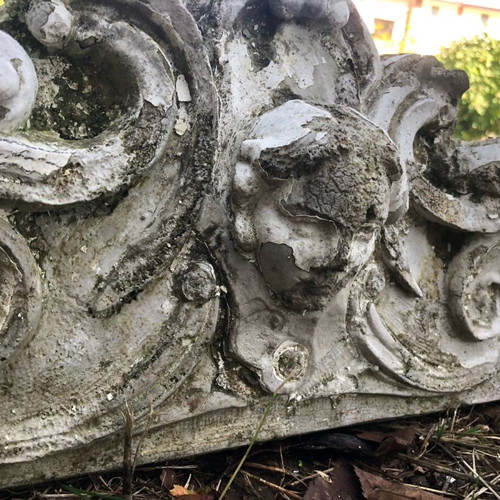 Old plaster pediment used with spiral motifs and human head