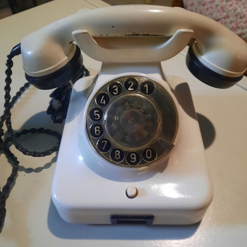 Old white bakelite telephone used, functional with cables