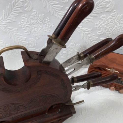 Wooden carved stand with used set of knives and forks