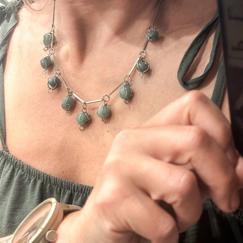 Silver necklace with green precious stones used