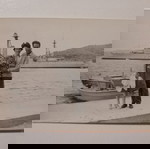  Μικρή, παλιά, φωτογραφία, με ζευγάρι να απολαμβάνει τη βόλτα στη θάλασσα, με θέα βάρκες και καράβια.