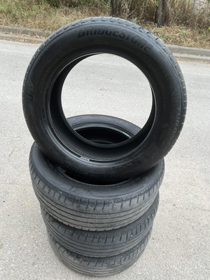 Bridgestone tire 235/55R18 104T used, one with curb damage