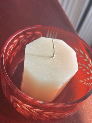 Candle with red container used, with signs of wear