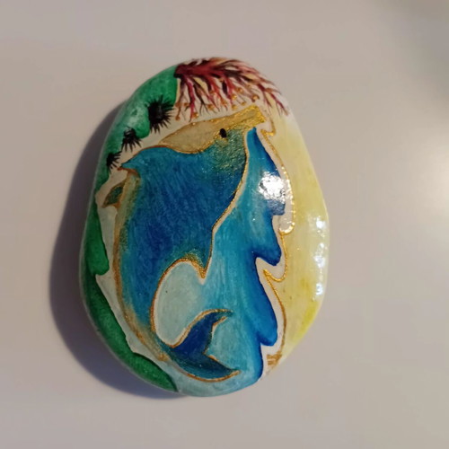 Painted pebble with dolphin theme, signed and varnished
