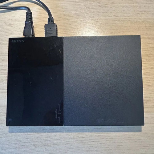 Sony PlayStation 2 Slim console used with DualShock 2 and cables