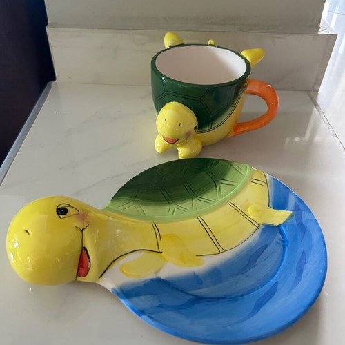 Vintage ceramic children's mug with turtle design used