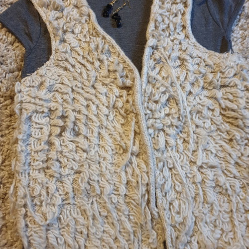 Grey turtleneck top, beige sleeveless fur vest and black stone earrings set