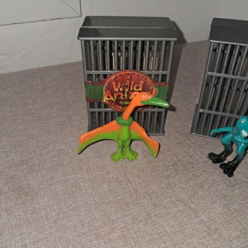 Dinosaur figures used, set in cages