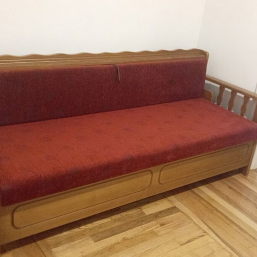Blue iron single bed with mattress and wooden sofa with storage