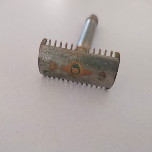 Vintage brass razor used with visible wear and oxidation