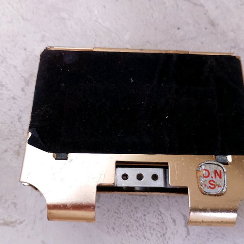 Vintage magnetic cigarette dispenser used, gold toned aluminum with leather panel