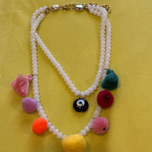 Necklace with white stones, evil eye, pom poms and tassels used