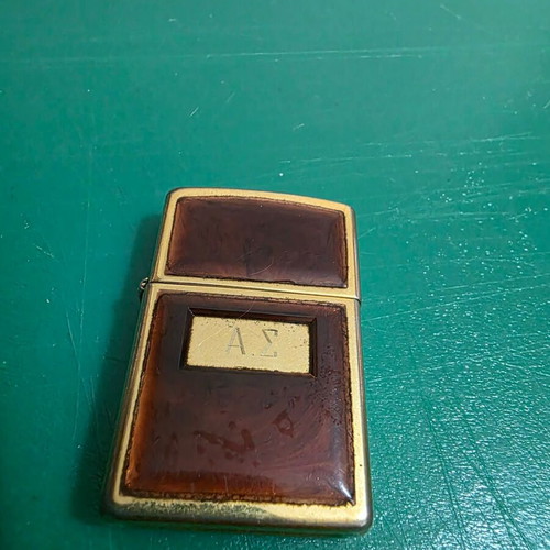 Vintage Zippo lighter in gold with glossy reddish frame