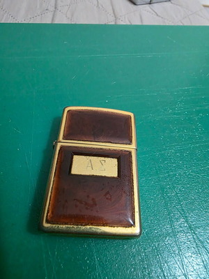 Vintage Zippo lighter in gold with glossy reddish frame