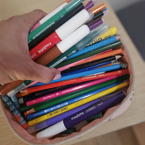 Makeup bag with markers, colored pencils, crayons, and watercolors used