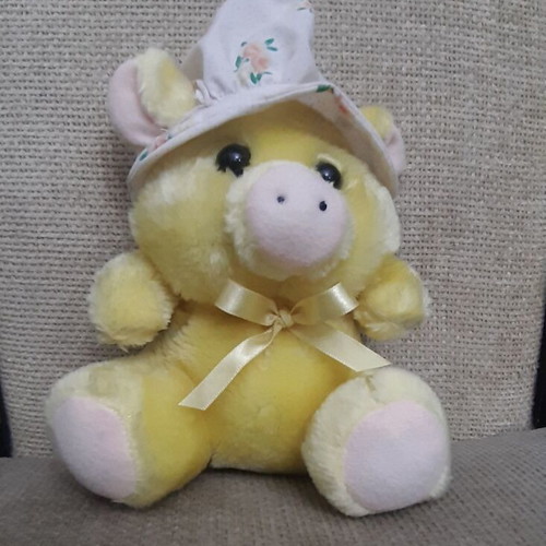 Yellow plush piglet with fabric hat and bow