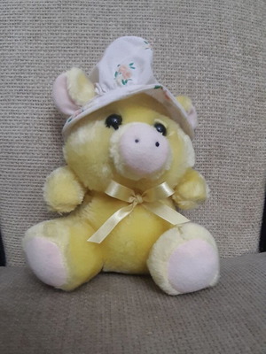 Yellow plush piglet with fabric hat and bow
