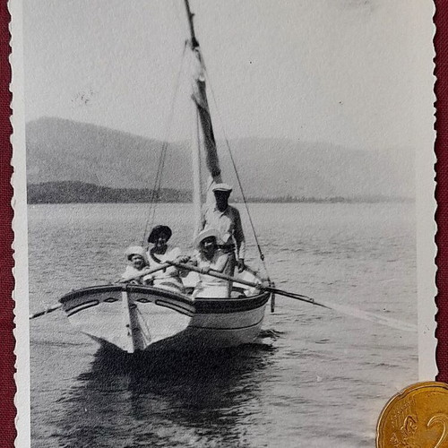Vintage black and white photo of group in wooden sailboat, 1950s