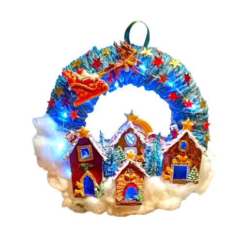Handmade wreath Santa Claus with sleigh in Christmas village lit with LED