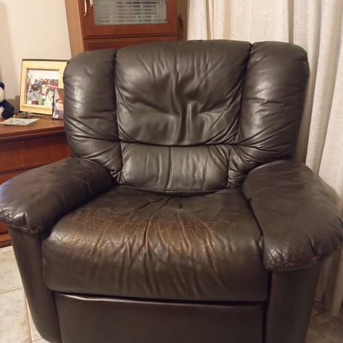 Leather recliner armchair used with wear on seat and footrest