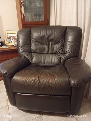 Leather recliner armchair used with wear on seat and footrest