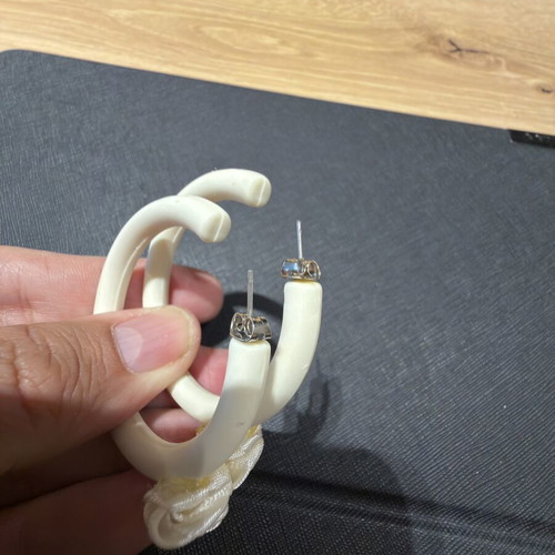 Pair of off-white matte resin hoop earrings with fabric floral accents