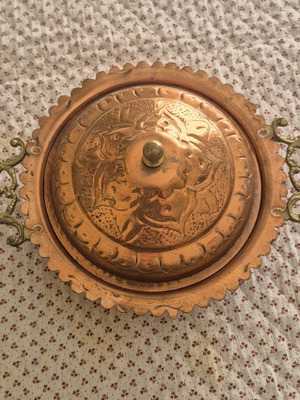 Traditional copper vessel with carved lid used