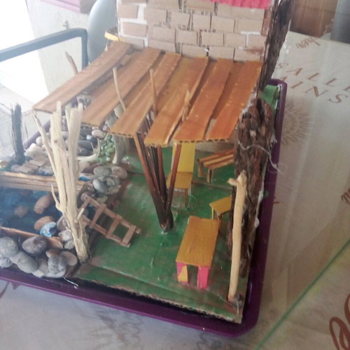 Handmade decorative house with cardboard, pebbles and driftwood, new