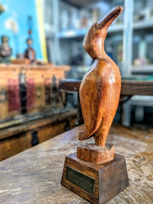 Дървена статуетка употребявана на Корморан с месингова плочка