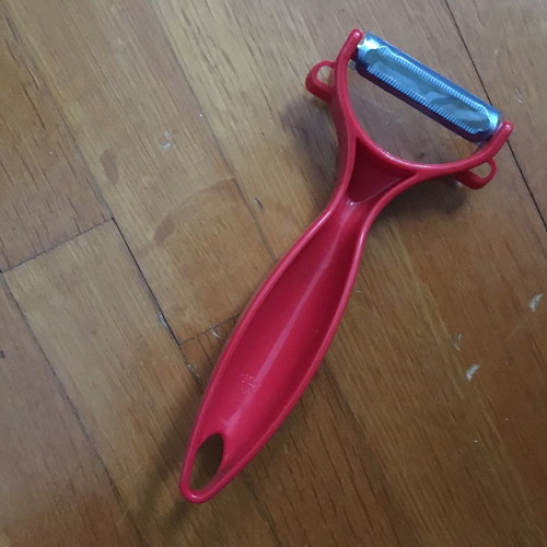 Red peeler new with thick handle made of durable plastic