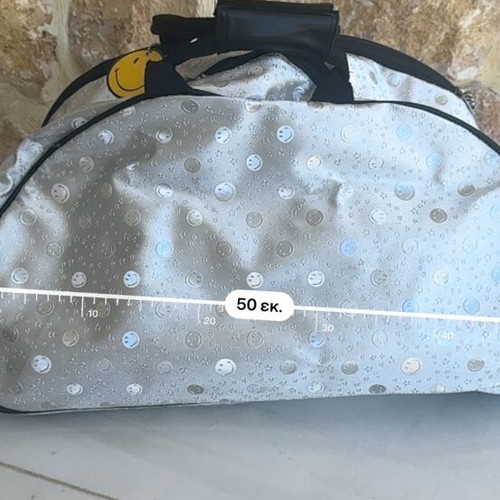 Smiley metallic travel bag used with embossed smiley and star designs